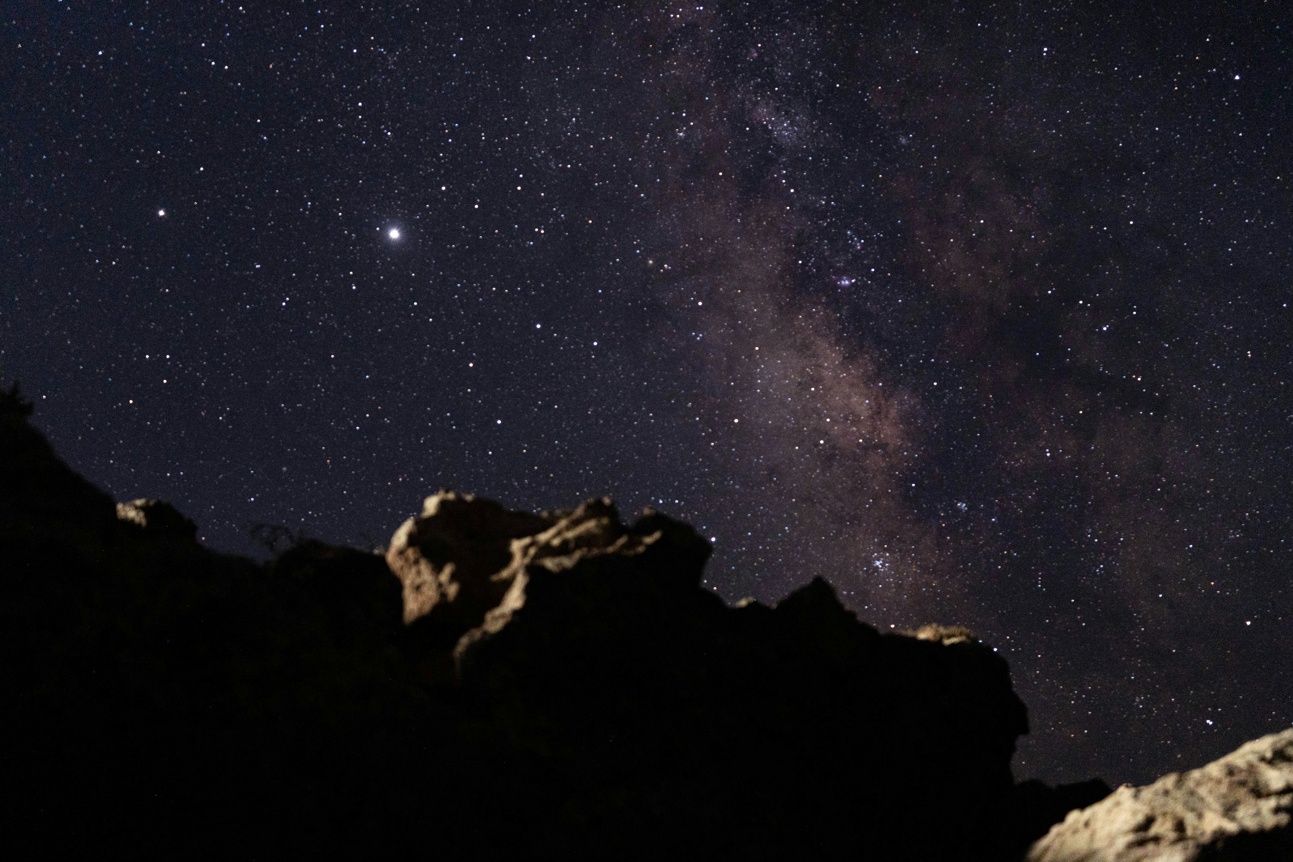 silhouette of mountain under starry night